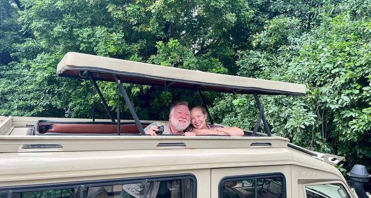 Menschen lächeln vom Dach eines Safari-Fahrzeugs