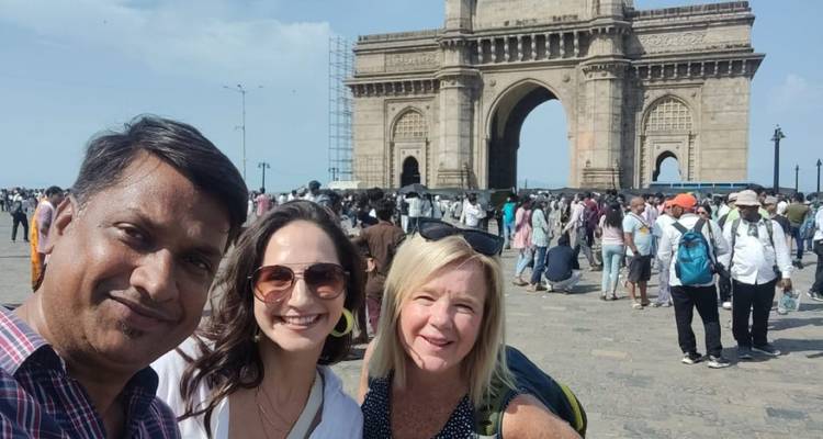 Touristen, die vor einem historischen Tor posieren.