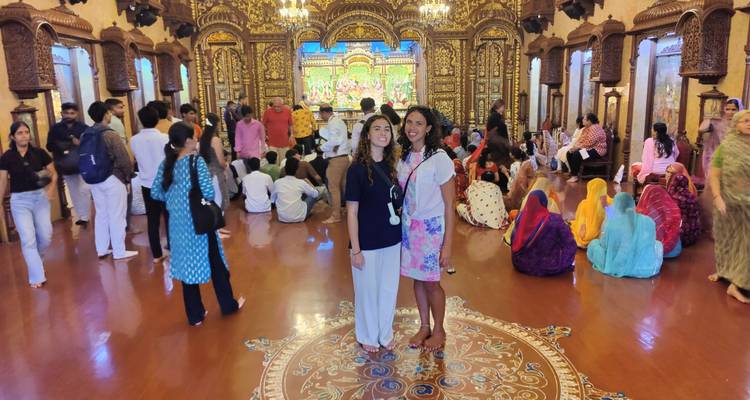 Frauen, die in einer farbenfrohen, dekorativen Tempelhalle posieren.