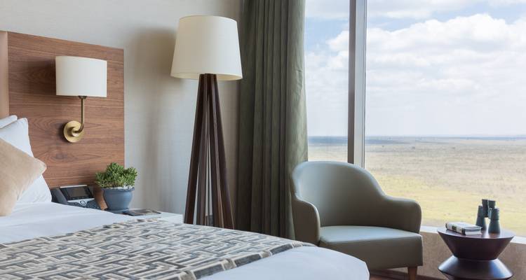 Een hotelkamer met uitzicht over uitgestrekte vlaktes.