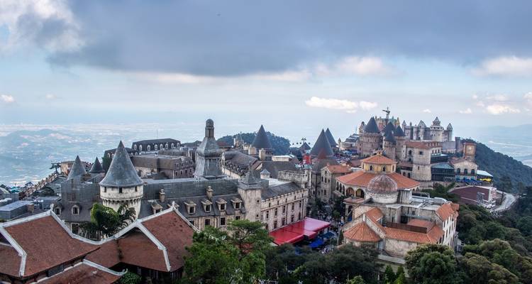 Zicht op een grote kasteelachtige structuur op een heuvel.