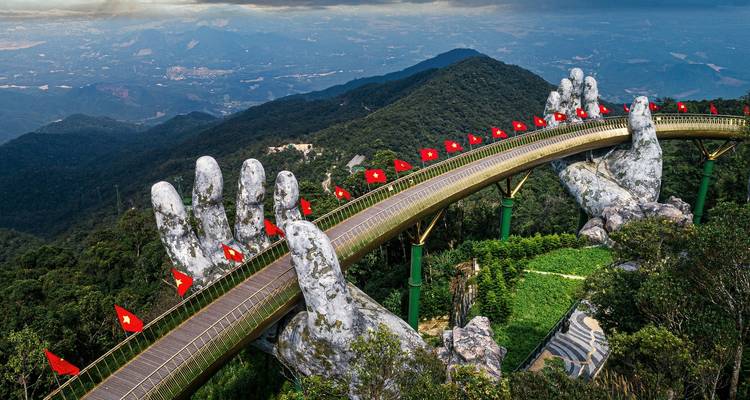 Gouden Brug met gigantische handsculpturen in de bergen.