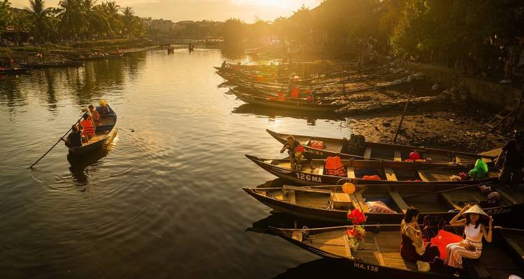 Groep mensen in boten op een zonovergoten rivier.