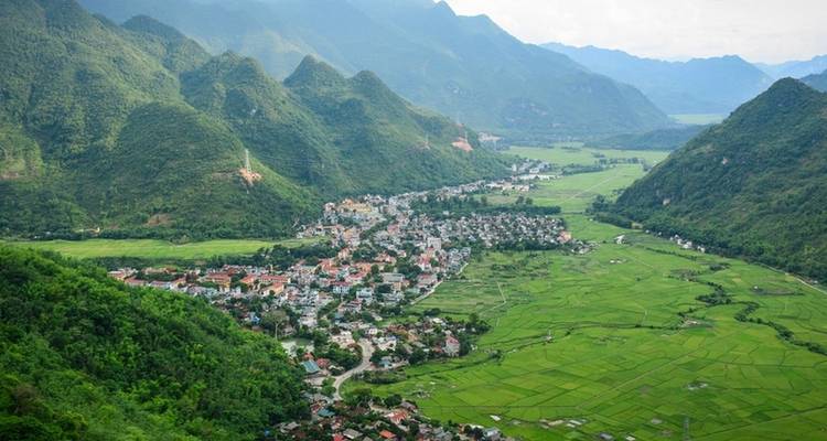 Aerial view of a town nestled in a valley surrounded by mountains.