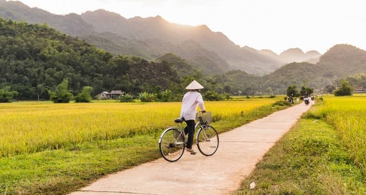 Person on a bicycle with a scenic mountain background.