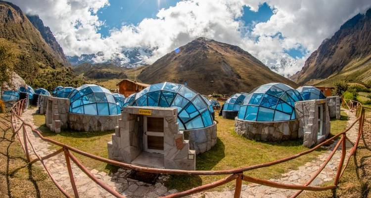 Alojamientos de cristal en forma de cúpula en un valle de montaña.