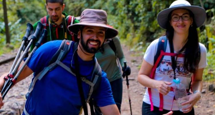 Grupo de excursionistas en el bosque sonriendo a la cámara.