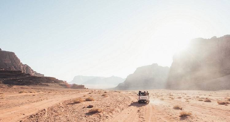 Véhicule tout-terrain traversant un paysage désertique.
