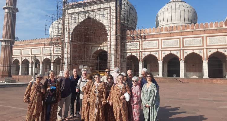 Groupe de touristes devant un bâtiment historique.