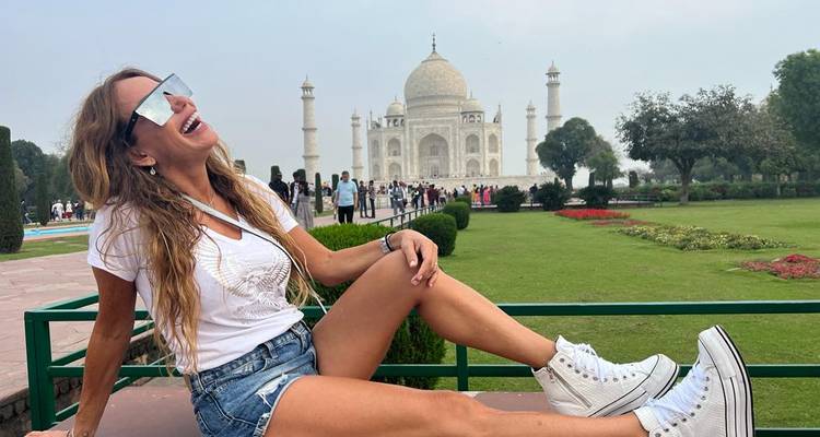 Individu posant de manière ludique devant le Taj Mahal.