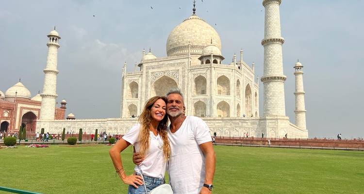 Couple debout devant le Taj Mahal.