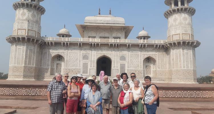 Groupe de touristes devant le tombeau d'Itimâd-ud-Daulâ avec une architecture détaillée en marbre blanc et des motifs ornementaux.