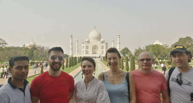 Groupe de personnes devant le Taj Mahal par une journée ensoleillée.