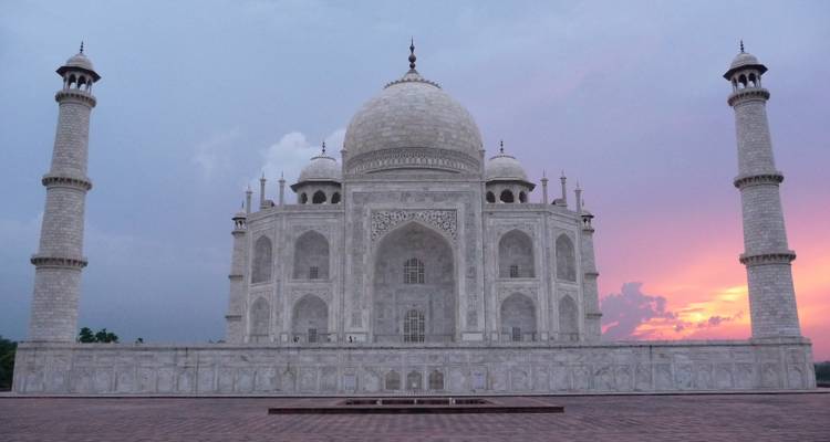 Taj Mahal captured from across a wide courtyard at dusk.