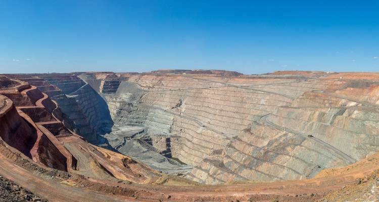 Panoramisch uitzicht over de enorme open-groeve Super Pit goudmijn onder een strakblauwe hemel.