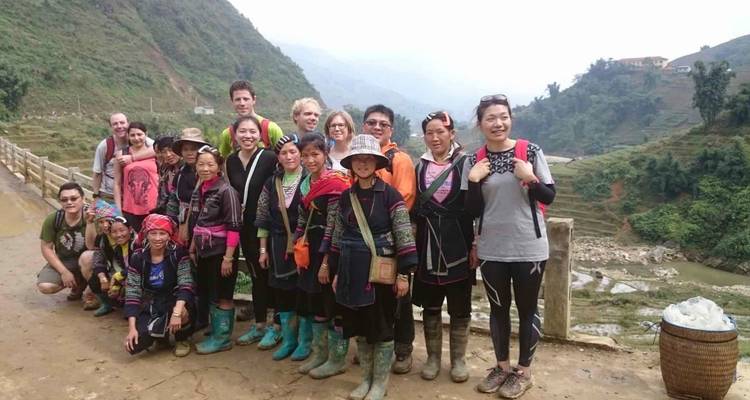 Groep toeristen en lokale bevolking in traditionele kledij.