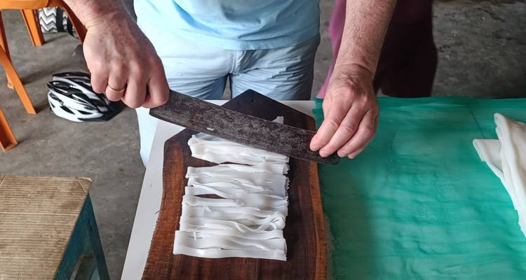 Person slicing white food items on a board.