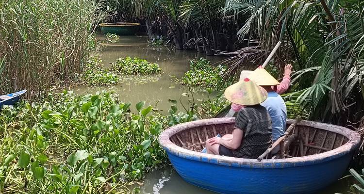 People in a small round boat in a natural setting.