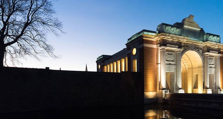 Menentor bei Abenddämmerung mit Bäumen im Vordergrund.