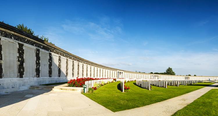 Mémorial de la Première Guerre mondiale avec des rangées de pierres tombales et des décorations florales.