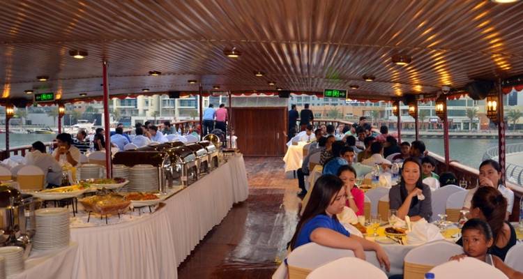 Menschen, die auf einem Boot mit Buffet und malerischem Blick aufs Wasser speisen.
