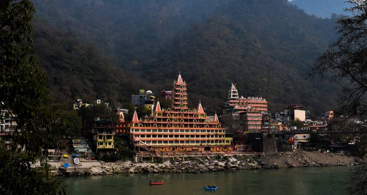 Groot tempelcomplex aan een rivier bij een heuvel.