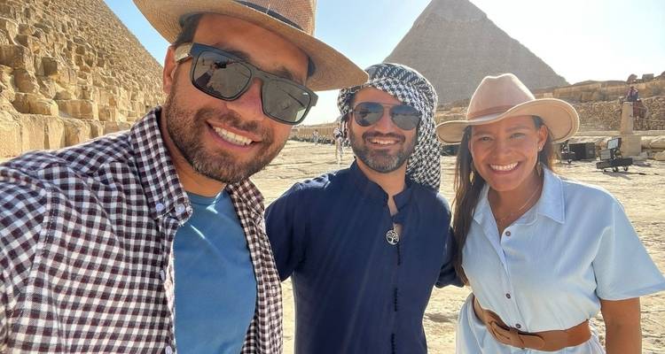 Trois personnes souriantes devant les pyramides.