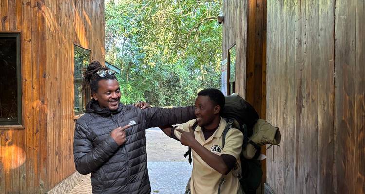 Deux hommes en tenue de plein air interagissant sur un sentier.