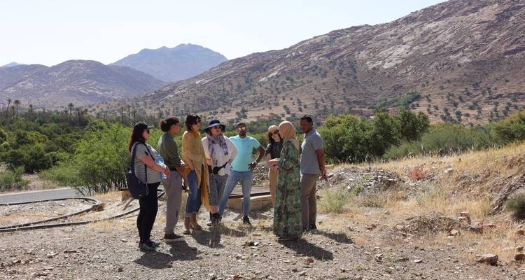 Gruppe von Menschen, die in einem Halbkreis nahe einem bergigen Gebiet stehen.