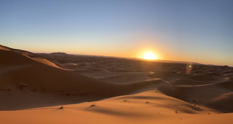 Atardecer sobre las dunas de arena en el desierto.
