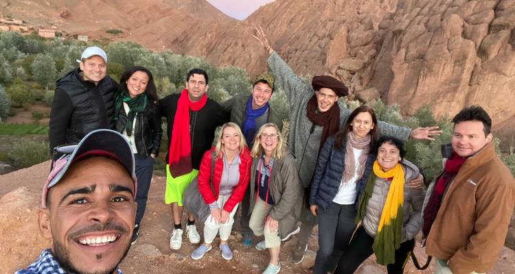Grupo de personas posando frente a formaciones de rocas rojas.