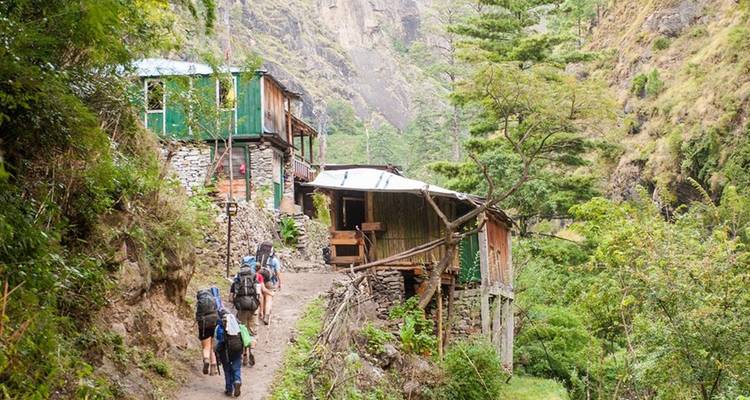Wanderer, die durch ein rustikales Bergdorf gehen.