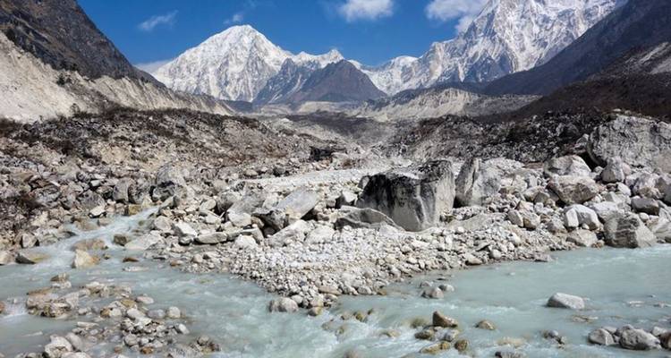 Gebirgsbach in den Rocky Mountains mit schneebedeckten Gipfeln in der Ferne.