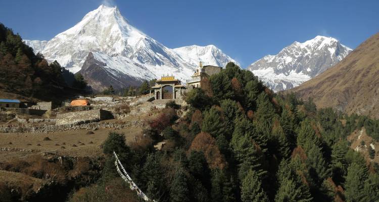 Tempel mit schneebedeckter Bergkette im Hintergrund.