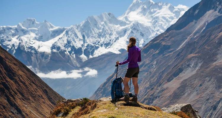 Ein Wanderer, der über eine malerische Berglandschaft blickt.