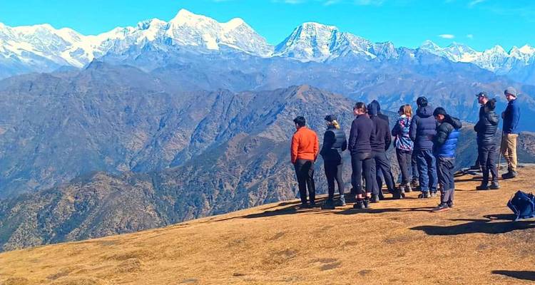Groep mensen die uitkijken naar verre bergen.