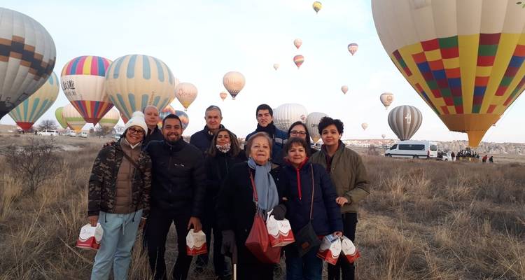 Group of people with hot air balloons in the background