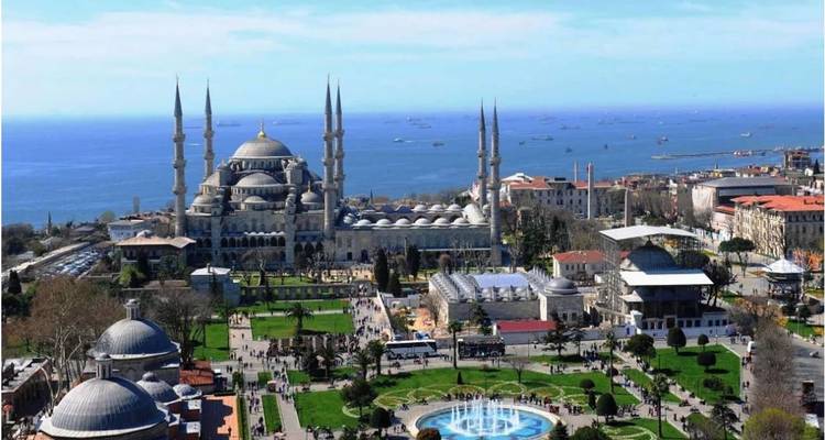 Skyline featuring a mosque next to the sea.