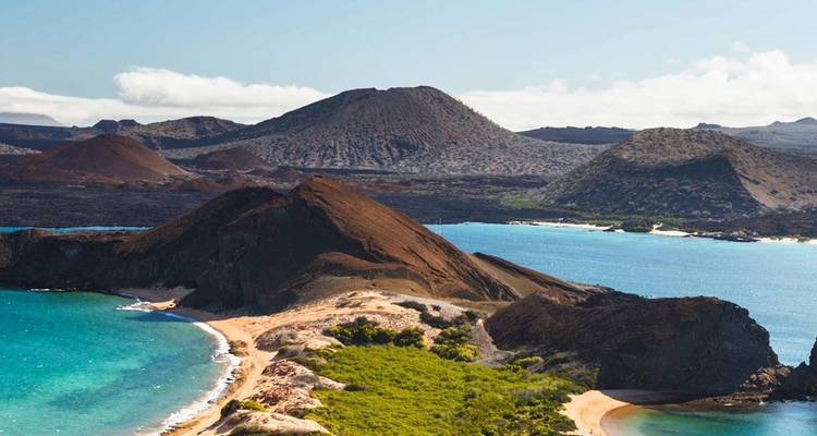 Paisaje volcánico icónico de las Galápagos con bahías turquesas, conos escarpados y playas de arena.