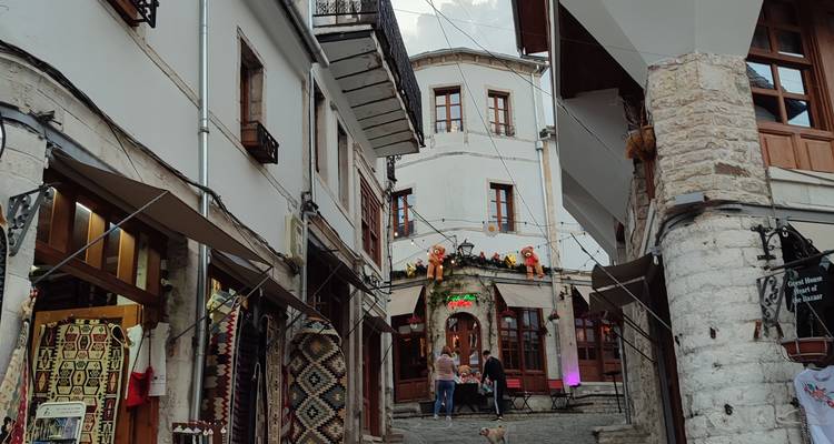Enge Straße mit traditioneller Architektur und Menschen, die spazieren gehen.