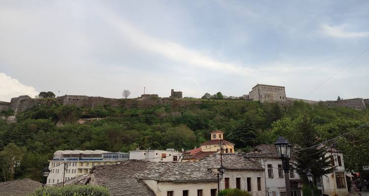 Festung auf einem Hügel mit Blick auf eine Stadt mit traditionellen Dächern.