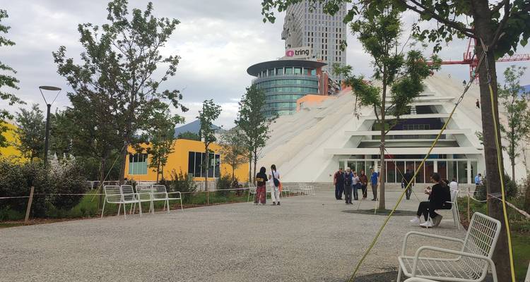 Stadtplatz mit Menschen, die um moderne Architektur herumgehen.