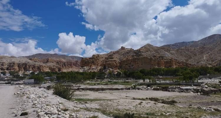 Woestijnlandschap met geërodeerde zandsteenkliffen en bewolkte lucht.