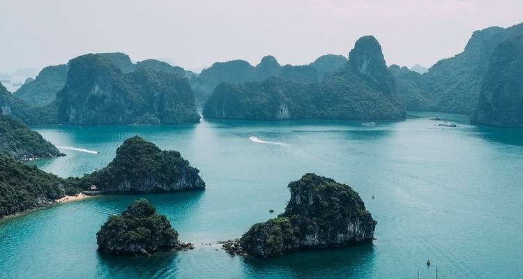 Îles calcaires spectaculaires et eaux turquoise, probablement la baie d'Halong.