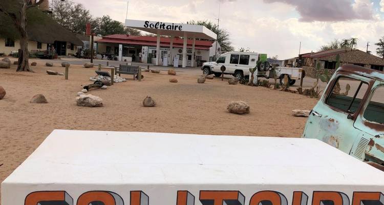 Gasolinera en un desierto con vehículos estacionados.