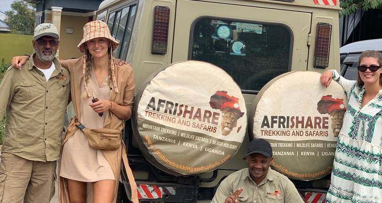 Groep poseert voor een safariwagen