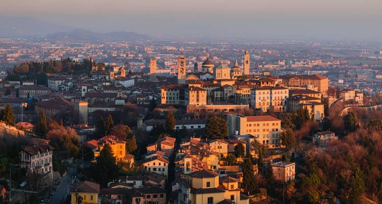 Vista del atardecer sobre el casco antiguo de Bérgamo con luz cálida en los tejados de terracota