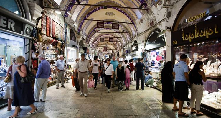 Een drukke overdekte bazaar met winkels die verschillende goederen uitstallen.