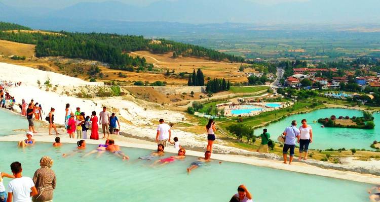 Mensen die genieten van thermale baden op een terras met schilderachtig uitzicht.