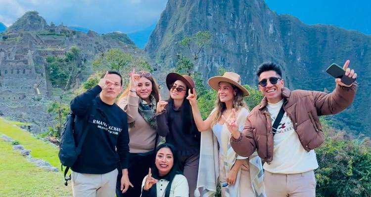 Groupe d'amis posant avec le Machu Picchu en arrière-plan.